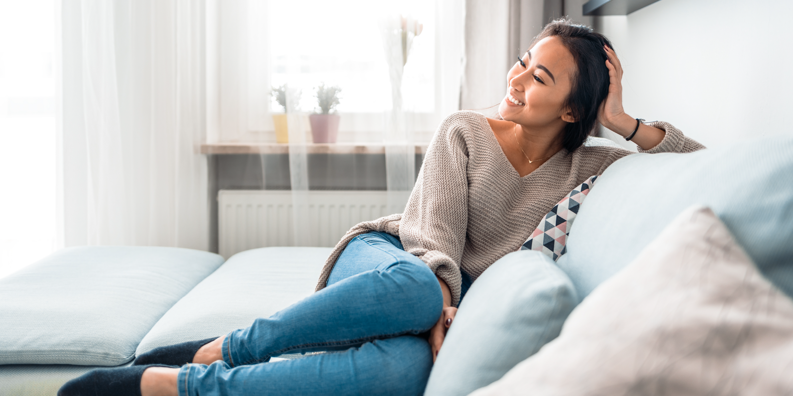 Woman with Canadian renter's insurance sitting on a couch and smiling